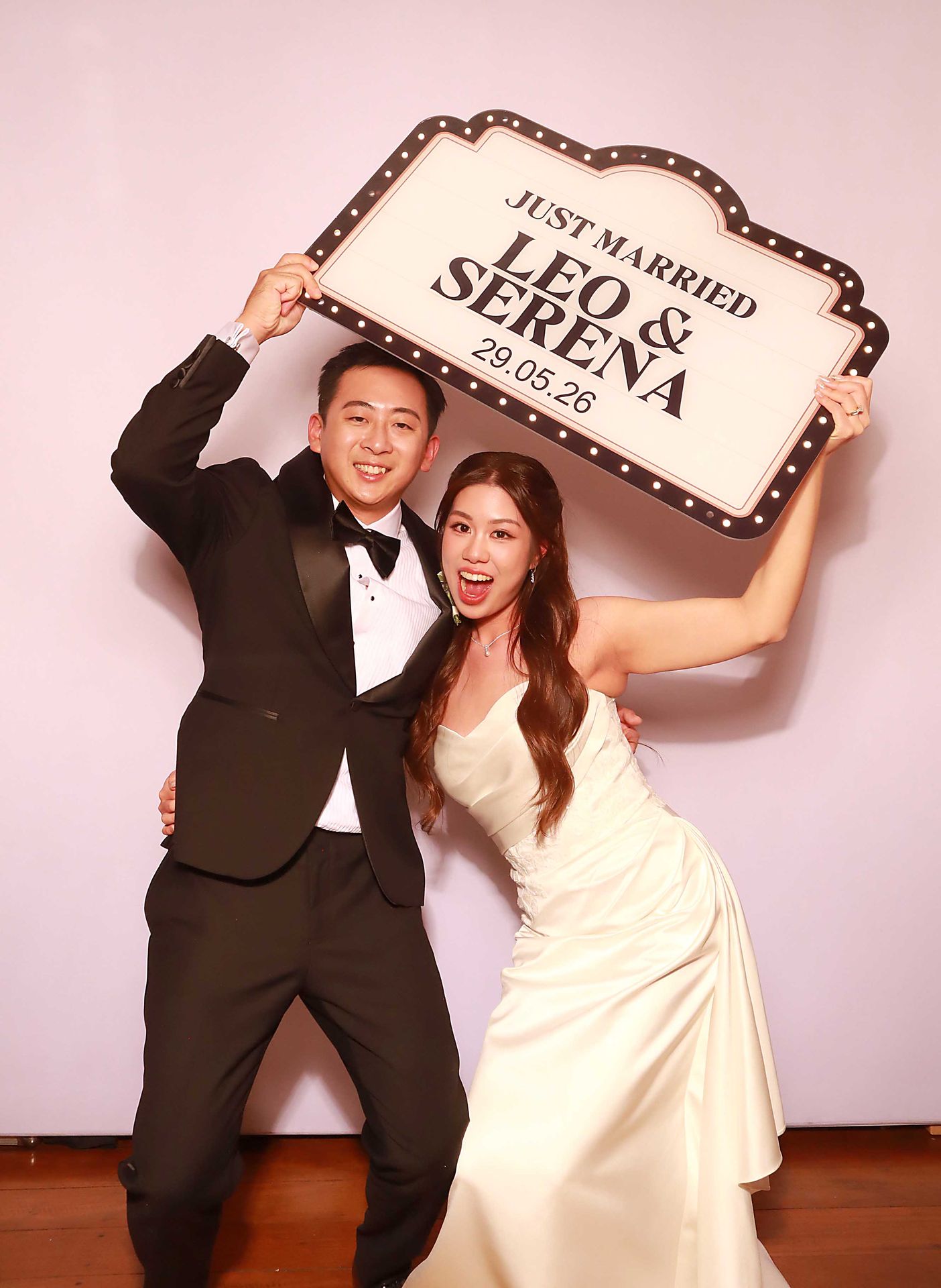 Two guests holding a sign in the Mirror Photo Booth